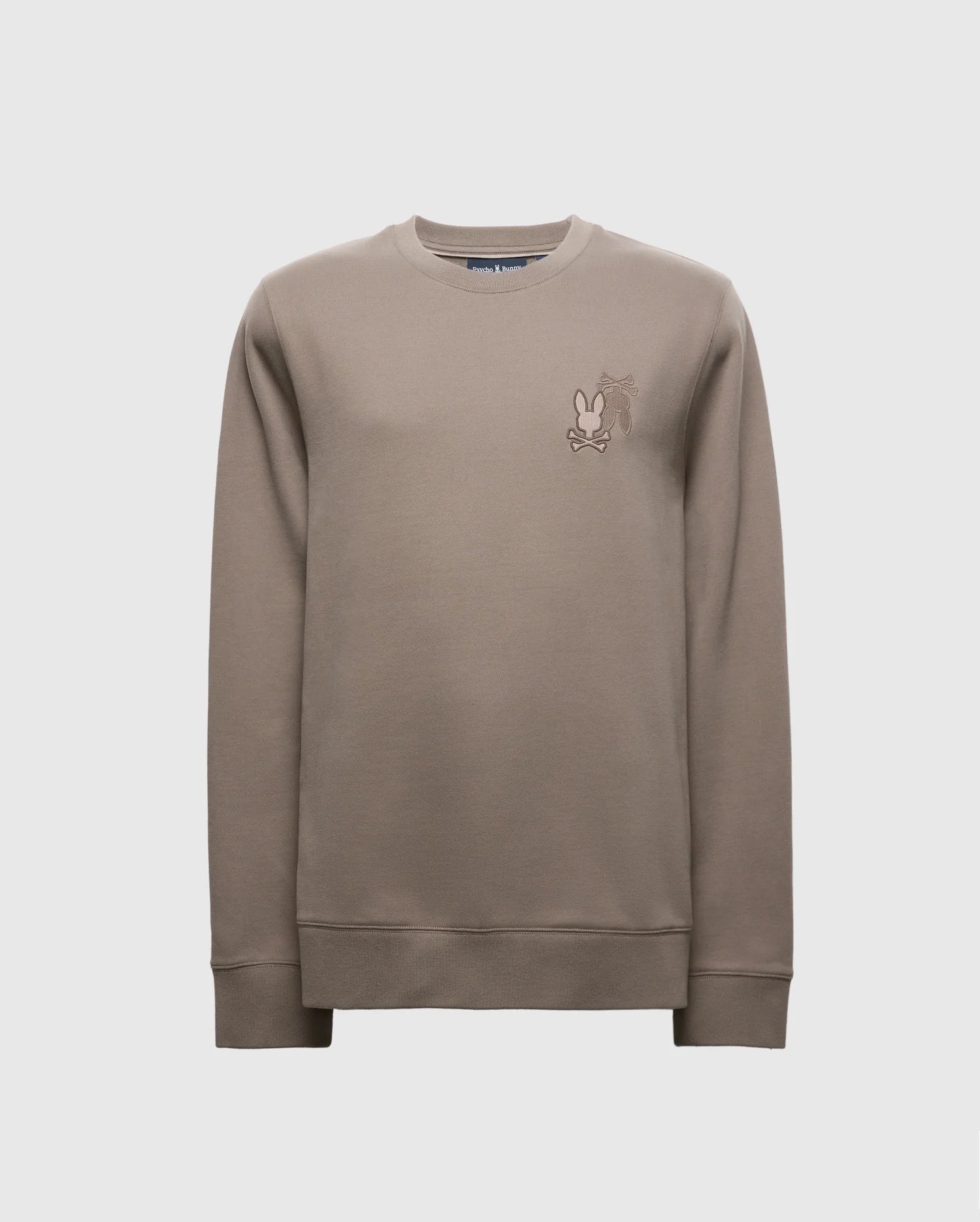 The Psycho Bunny MENS PIERCE PEACHED TERRY CREW - B6S278E200 sweatshirt in taupe features a small cartoon character embroidered on the upper left chest. Made from high-quality cotton, it includes ribbed cuffs, hem, and a classic crew neckline for a stylish appearance.