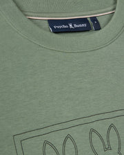 A close-up view of the green Mens Tacoma Sweatshirt by Psycho Bunny highlights its luxurious comfort and stitched bunny ear outline on the front, with the label prominently displayed beneath the collar. The premium stretch fabric guarantees a perfect fit while maintaining a lightweight feel.