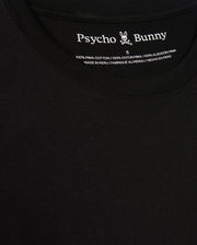 A close-up of the black Psycho Bunny Men's Alberton Long Sleeve Tee – B6T867D200 highlights its label. This fashion masterpiece features the "Psycho Bunny" name alongside a bunny logo and is detailed in white text: "100% Pima Cotton," "Made in Peru," and size "5".