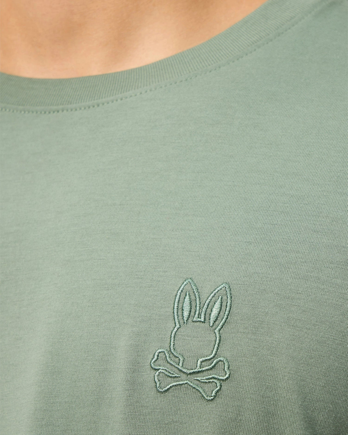 Get a closer look at the MENS ALBERTON LONG SLEEVE TEE - B6T867D200 by Psycho Bunny, crafted from luxurious Pima cotton. It showcases an embroidered bunny head logo with crossed bones on the chest.