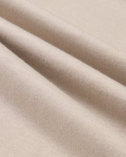 A close-up of the MENS ALBERTON LONG SLEEVE TEE - B6T867D200 by Psycho Bunny highlights the beige fabric elegantly folded to showcase its smooth texture and fine weave. This Pima cotton tee exemplifies flexibility and softness, making it the perfect choice for a luxurious layering piece.