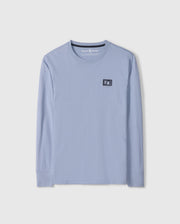 The Psycho Bunny MENS MONROE LONG SLEEVE TEE - B6T975D200, in light blue, is a comfortable long-sleeve t-shirt made from pima cotton. It features a round neckline and a small black patch with a white design on the upper chest for added versatile style.