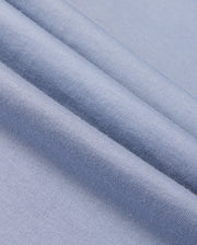Close-up of folded light blue fabric from the Psycho Bunny MENS MONROE LONG SLEEVE TEE - B6T975D200, highlighting its smooth texture and fine weave. Crafted from pima cotton, it embodies classic comfort.