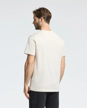 A man with brown hair, facing away from the camera against a plain background, wears a Psycho Bunny MENS CLASSIC CREW NECK TEE - B6U014B200 in vibrant colors, paired with black pants.