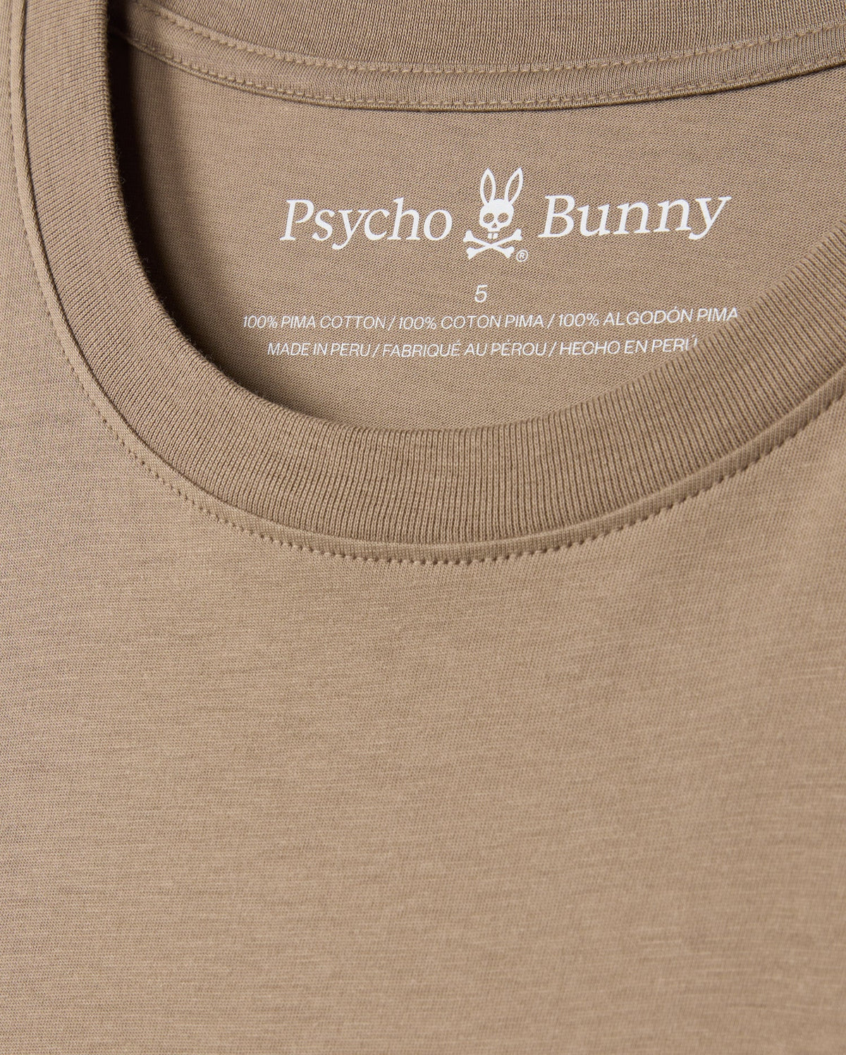 Close-up of the men's MENS CLASSIC CREW NECK TEE - B6U014CRPC in khaki, showcasing the distinctive Psycho Bunny embroidered logo along with text inside the collar. Crafted from 100% Pima cotton in Peru, this t-shirt delivers exceptional comfort and style.