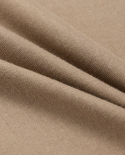 Close-up of a light brown fabric, showcasing soft folds and a smooth texture. Crafted from 100% Pima cotton, this material is stretchy and comfortable, making it perfect for the Psycho Bunny Men's Classic Crew Neck Tee (B6U014CRPC).