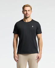 A man is standing against a plain white background, wearing the Psycho Bunny MENS CLASSIC CREW NECK TEE - B6U014CRPC, crafted from 100% Pima cotton with a small embroidered logo on the left chest.