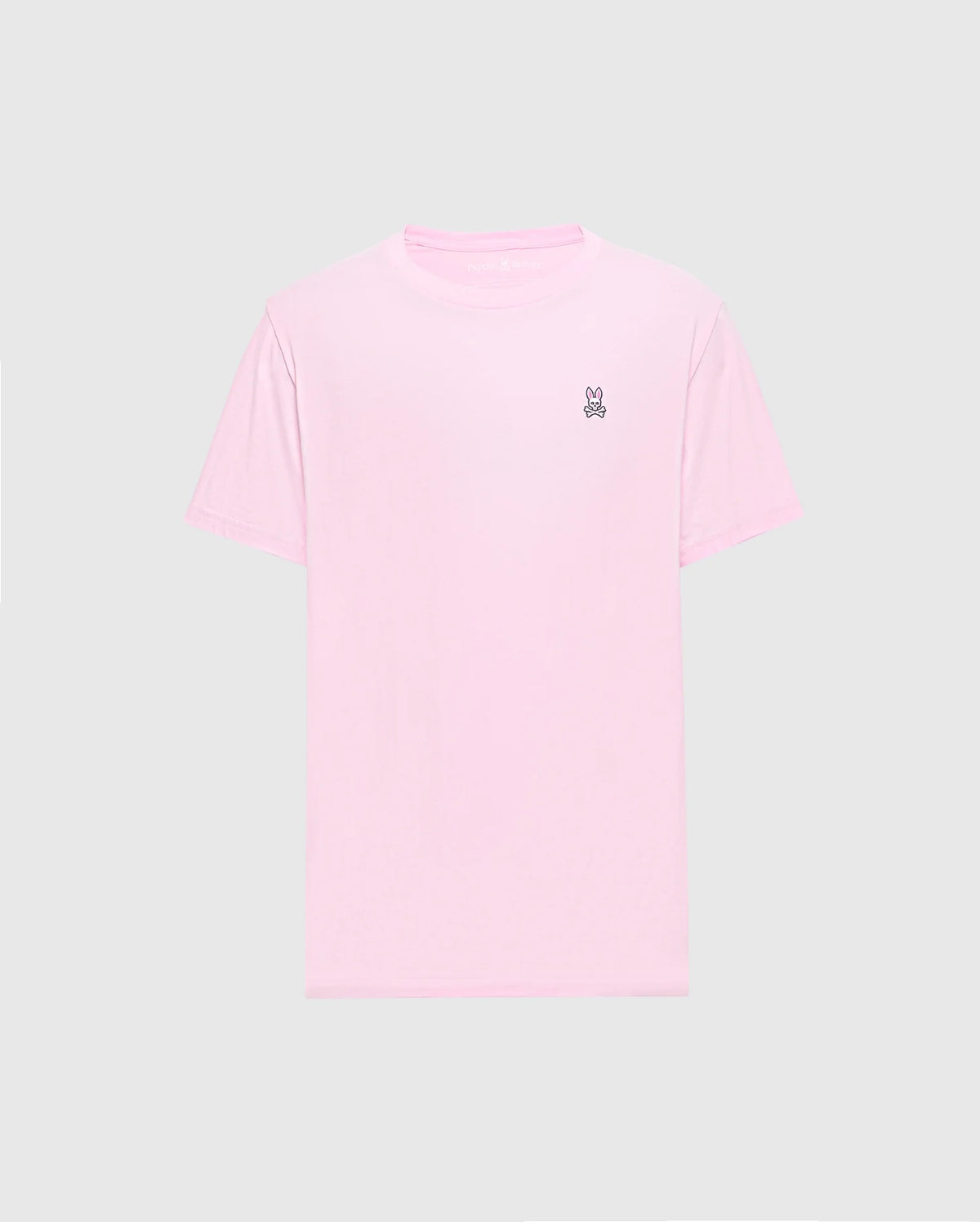 The light pink Men's Classic Crew Neck Tee (B6U014CRPC) by Psycho Bunny is crafted from soft pima cotton with a small embroidered peace sign hand symbol on the top left chest against a plain gray background, making it versatile and stylish for any casual occasion.