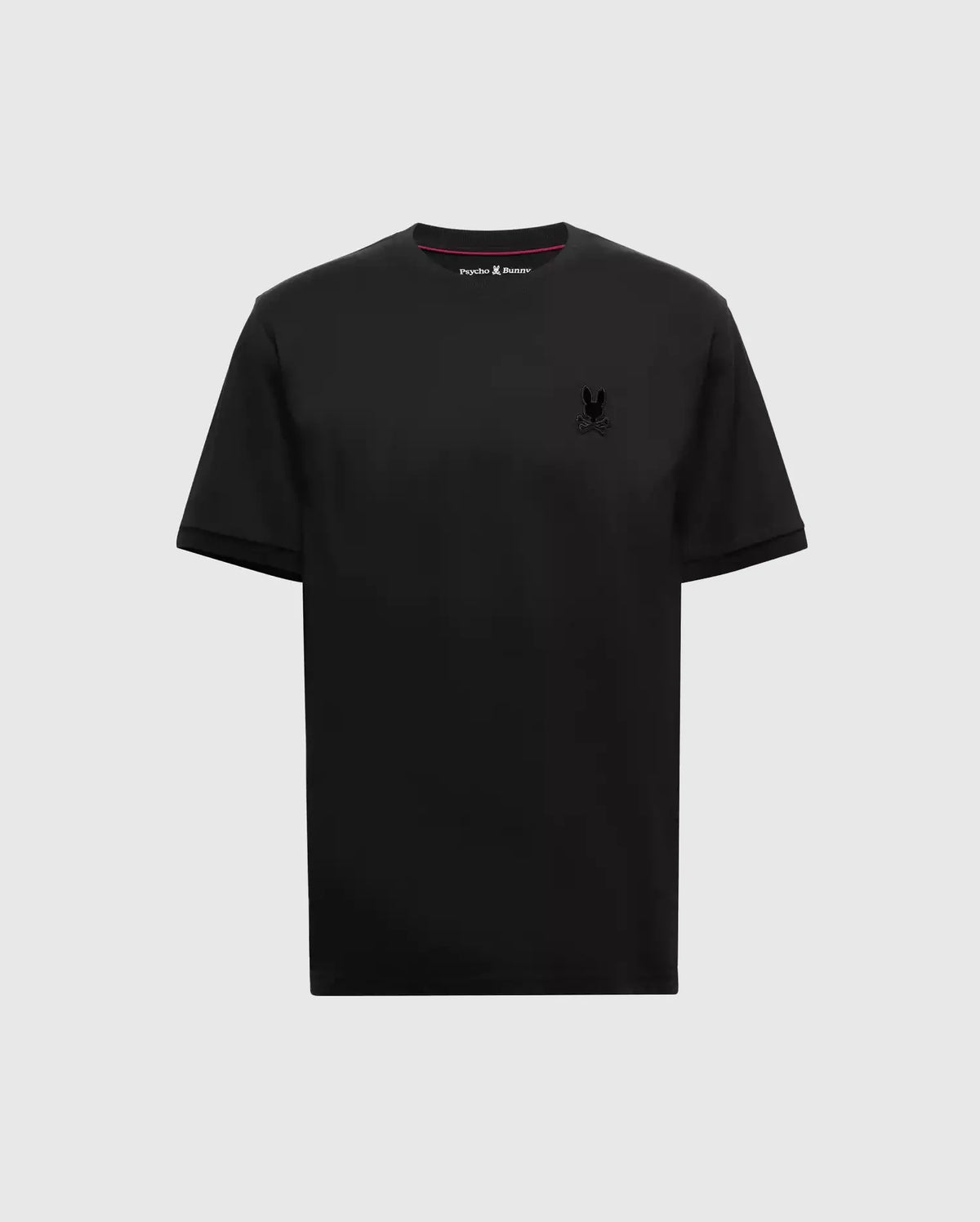 The MENS BRANSON FASHION TEE - B6U137E200 by Psycho Bunny in sleek black is set against a plain gray background, highlighting its premium quality and lightweight design. This tee features a small, subtle logo on the upper left chest, blending comfort with style seamlessly.