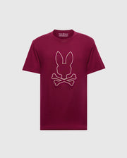 The Psycho Bunny MENS ALEXANDER GRAPHIC TEE - B6U163E200 is a striking maroon men's graphic t-shirt made from soft Pima cotton, featuring a bold graphic of a bunny head above crossed bones against a plain light gray backdrop.