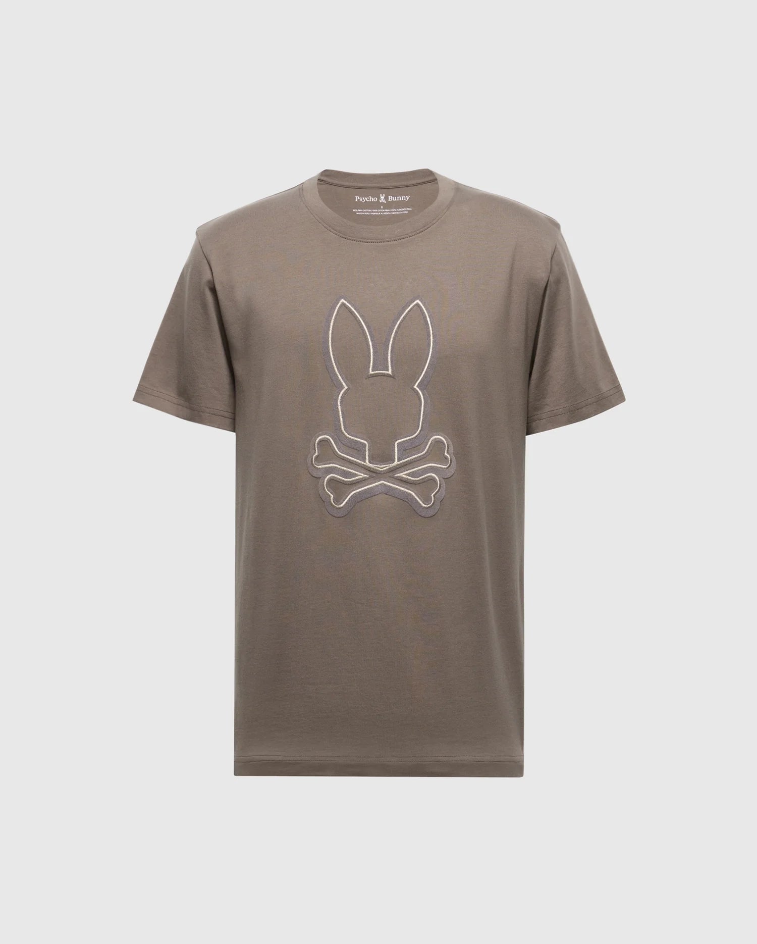 The Men's Alexander Graphic Tee - B6U163E200 by Psycho Bunny features a bold brown color with a distinctive white outline of rabbit ears above crossed bones, reminiscent of the classic skull and crossbones motif. Crafted from soft Pima cotton, it ensures both comfort and style in one unique package.