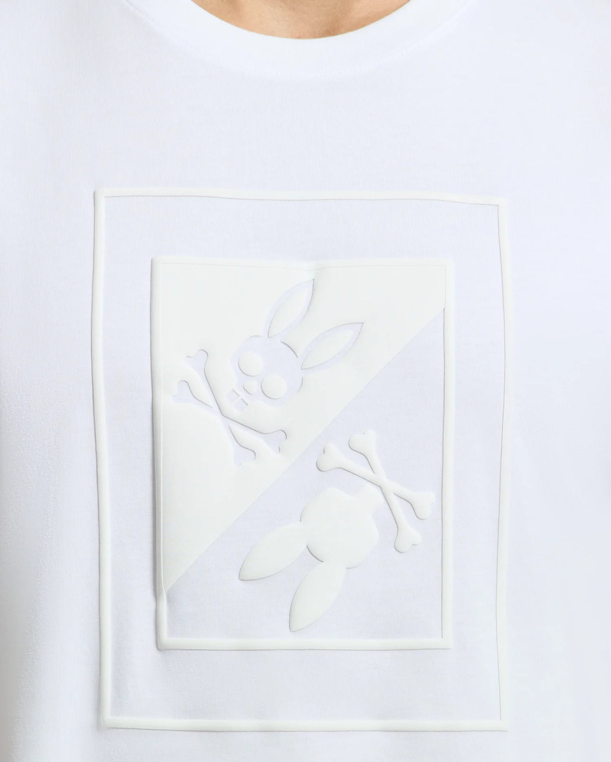 The Psycho Bunny MENS DOTSER GRAPHIC TEE - B6U197E200 features a diagonally divided design of a raised skull adorned with bunny ears and crossbones, crafted on high-quality Peruvian Pima cotton.