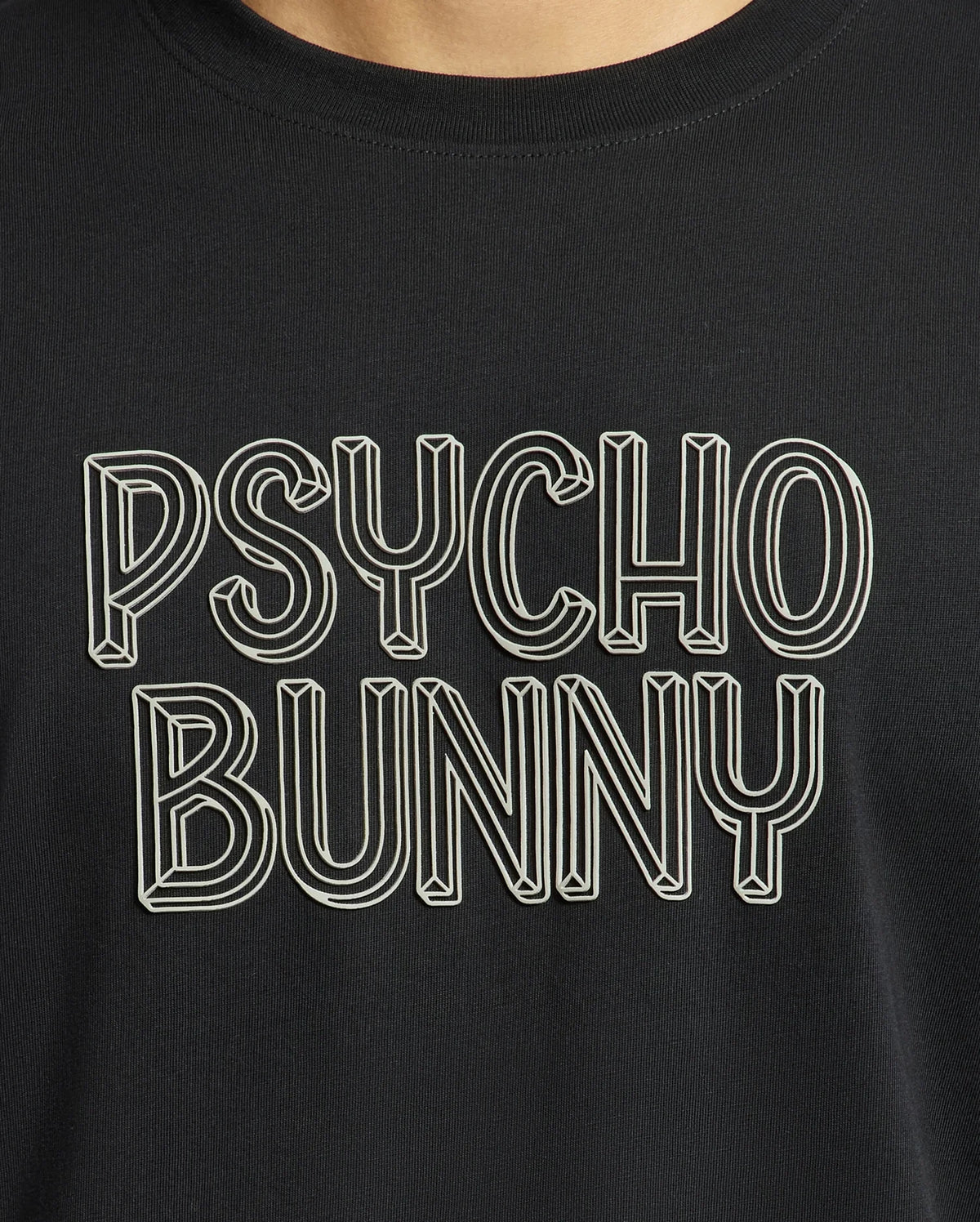 A close-up of the Mens Monarc Wordmark Graphic Tee - B6U210E200 from Psycho Bunny showcases bold white outlined text reading "PSYCHO BUNNY" in a stylized, three-dimensional font against a black backdrop. Made from 100% Pima cotton, it provides a regular fit that ensures ultimate comfort and style.