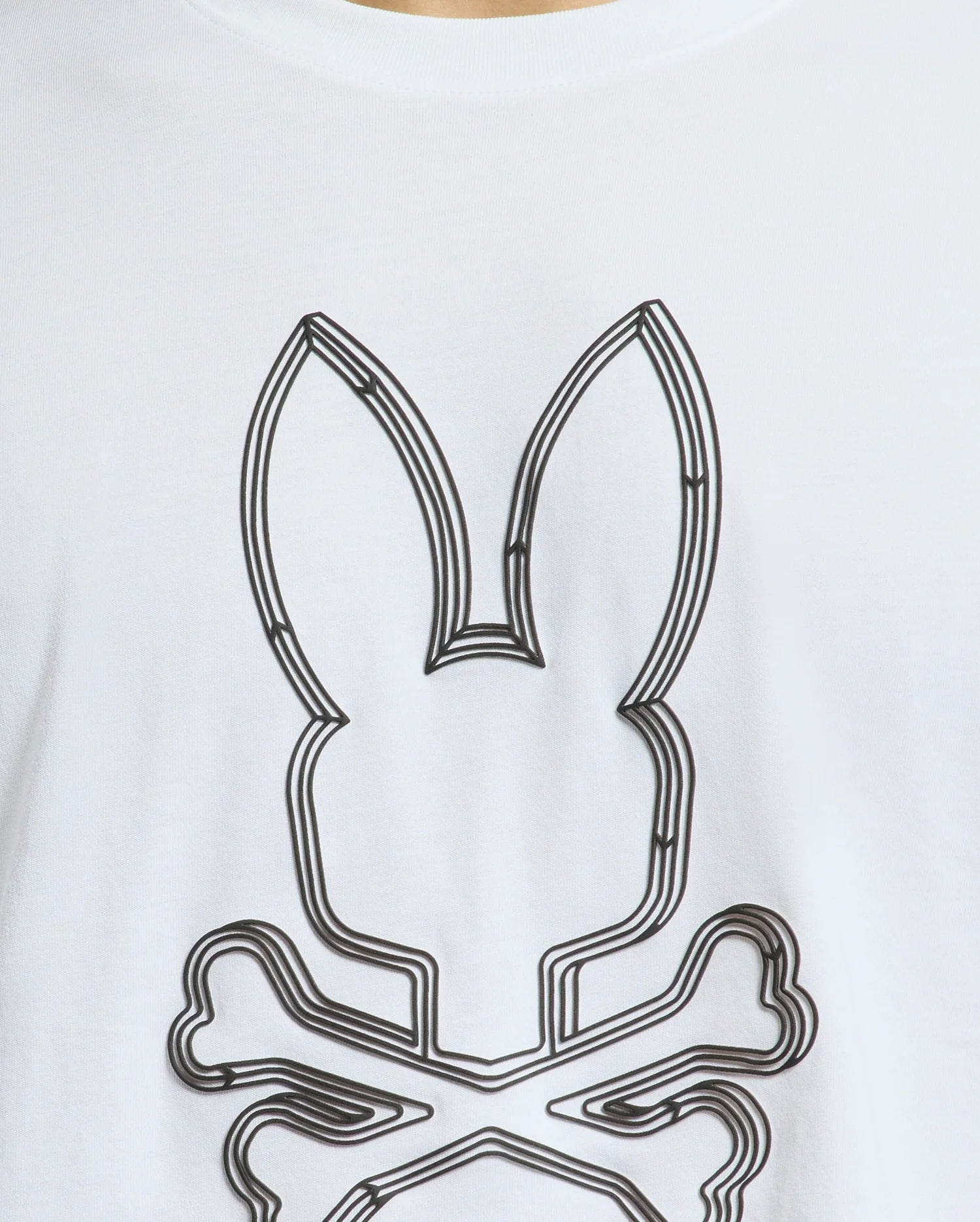 This close-up showcases the Mens Monarc Front Bunny Graphic Tee (B6U211E200) from Psycho Bunny. Made in Peru using 100% Pima cotton, this tee features an abstract bunny with ears outlined in black lines set above a skull and crossbones motif, offering an avant-garde twist to your style.