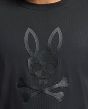 The Psycho Bunny MENS PAYSON LEATHER PRINT GRAPHIC TEE (B6U213E200) features a striking skull with rabbit ears above crossed bones design on soft Pima cotton jersey.