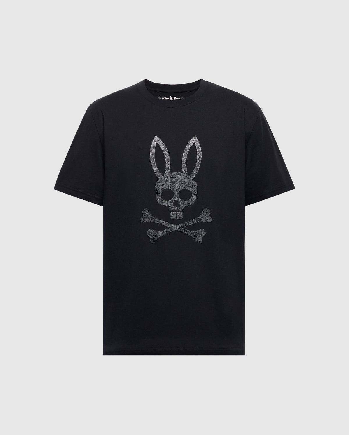 Psycho Bunny’s MENS PAYSON LEATHER PRINT GRAPHIC TEE - B6U213E200 is a black Pima cotton jersey tee with a silver skull featuring bunny ears and crossbones design on the front.