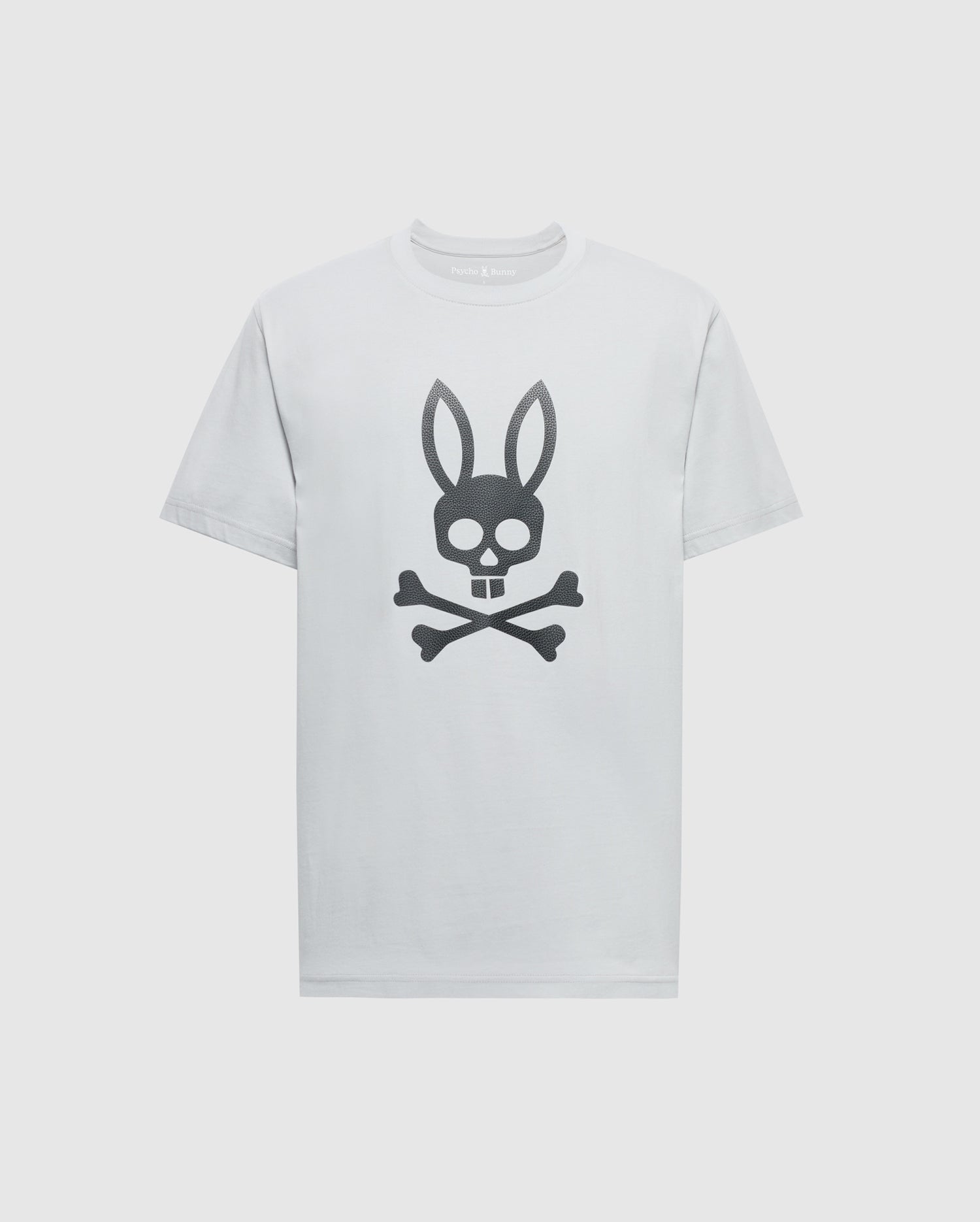 The Psycho Bunny MENS PAYSON LEATHER PRINT GRAPHIC TEE (B6U213E200) features a black skull and crossbones with bunny ears design on white Pima cotton, creating a striking look against the plain background.