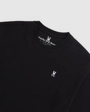 A black MENS OVERSIZED CLASSIC CREW NECK TEE - B6U240W1PC from Psycho Bunny, featuring the brand's Embroidered Bunny logo—a white bunny with crossed bones beneath it—stitched in pink and white on the left chest. Made from luxurious Peruvian Pima cotton, the inner collar showcases the brand name and logo in white text on a black background.
