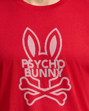The MENS DUMON GRAPHIC TEE - B6U271E200 by Psycho Bunny is a men's T-shirt made from 100% Peruvian Pima cotton. It showcases a red design featuring a bunny head with elongated ears above crossed bones, along with bold, striped "Psycho Bunny" lettering.