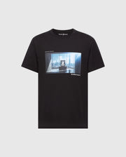 The MENS WARREN PHOTO REAL TEE - B6U388E200 by Psycho Bunny is a stylish black T-shirt featuring a room with large windows and city skyline image, centered with a white logo. "SUPER RICH" is on the upper left and "Alexander" on the lower right. Made from premium Pima cotton for comfort.