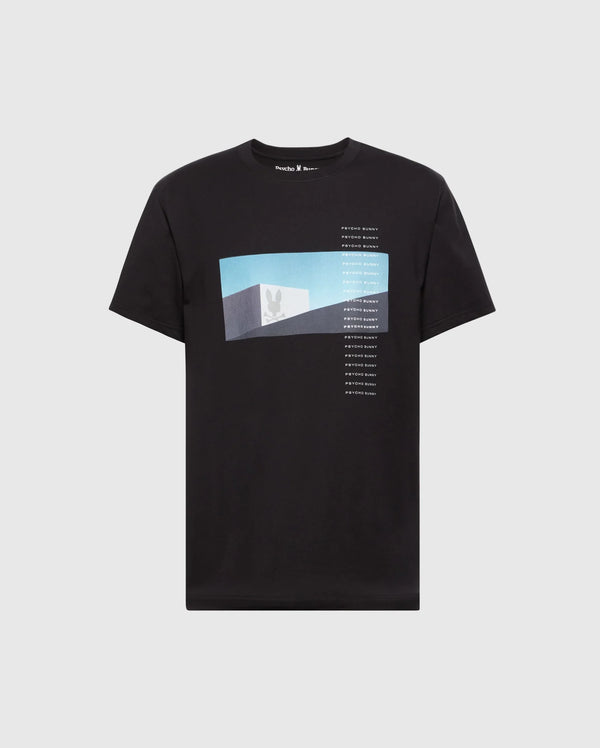 The Psycho Bunny MENS NEIL PHOTO REAL TEE (B6U389E200) is a black jersey Pima cotton t-shirt showcasing a sky view silhouette graphic with vertical text, combining comfort with modern style.
