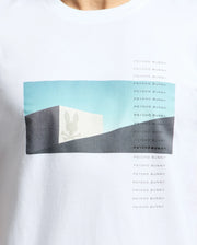 Introducing the Psycho Bunny Men's Neil Photo Real Tee: a white t-shirt made from Peruvian Pima cotton, featuring a cube with a bunny skull against a blue and gray abstract background, with "PSYCHO BUNNY" printed in small text reminiscent of brutalist architecture.