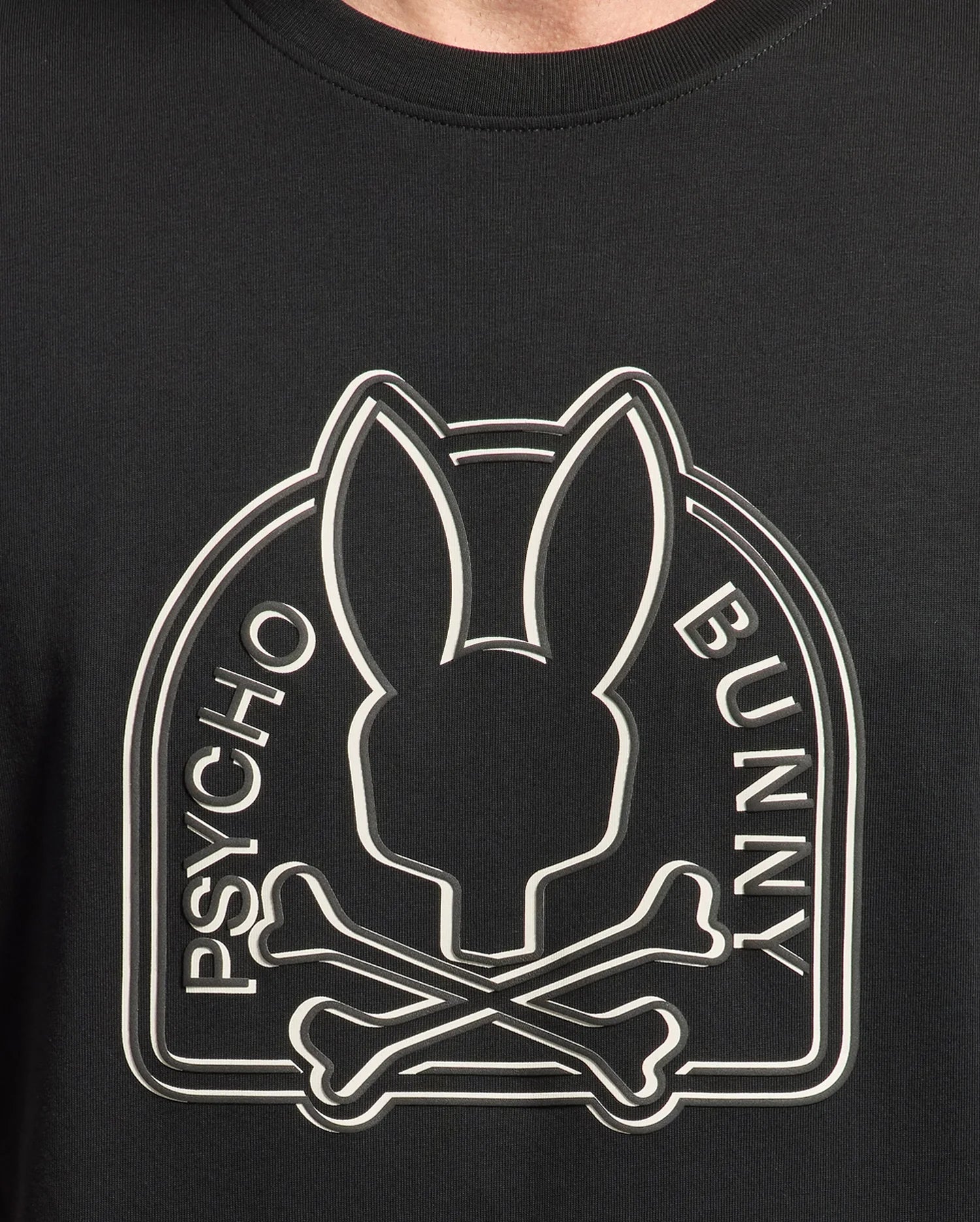 A close-up of the black Psycho Bunny mens Melbourne graphic tee made from Peruvian Pima knit, showcases a stylized bunny head above crossed bones with "Psycho Bunny" on either side.