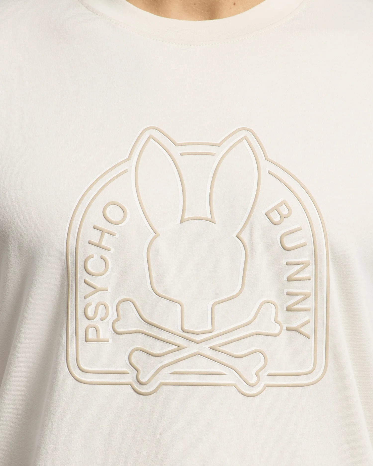 The Psycho Bunny MENS MELBOURNE GRAPHIC TEE - B6U410F200, made from luxurious Peruvian Pima cotton, features a white t-shirt with an embossed bunny silhouette above crossed bones and swirling "PSYCHO BUNNY" text, offering an eco-friendly style.