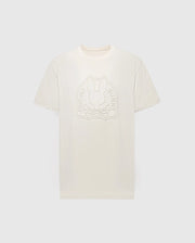The MENS MELBOURNE GRAPHIC TEE by Psycho Bunny is a beige T-shirt made from Peruvian Pima cotton. It features an embossed rabbit and crossbones design, encircled by "Psycho Bunny," set against a light grey background in an eco-friendly style.