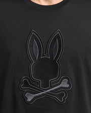 Close-up of the Psycho Bunny MENS NEW CASTLE GRAPHIC TEE in black, crafted from soft Pima cotton, featuring an embroidered Bunny emblem with a rabbit head silhouette and crossed bones for a unique skull and crossbones design.