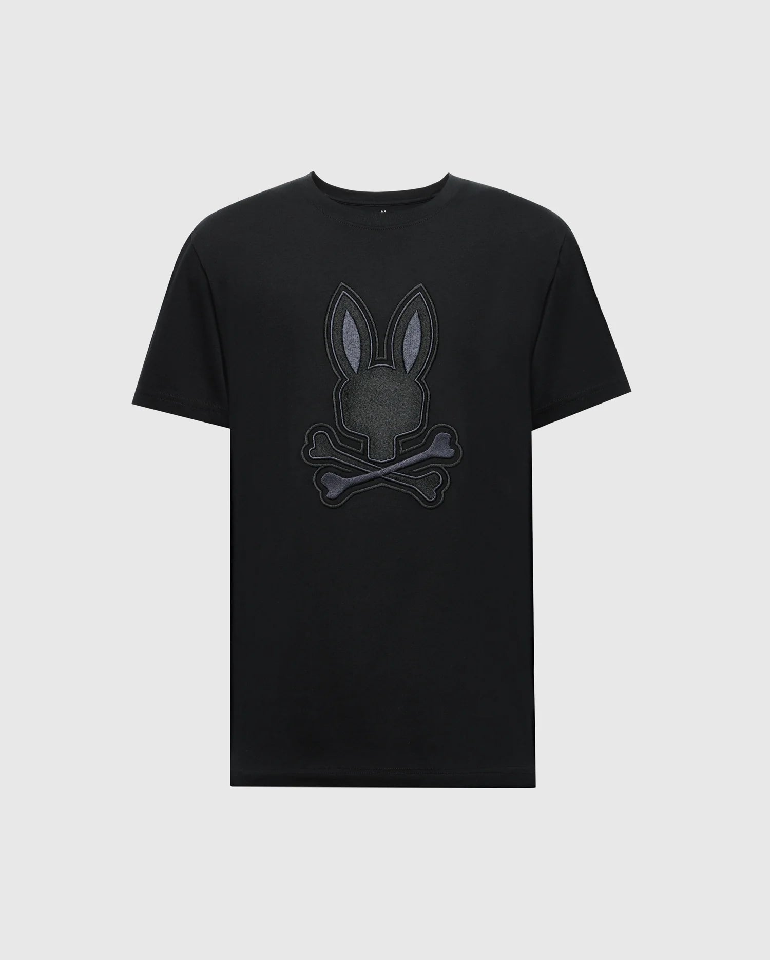 The Psycho Bunny MENS NEW CASTLE GRAPHIC TEE (B6U415F200) features a stylized embroidered bunny head with crossbones on a black Pima cotton T-shirt against a plain white background.