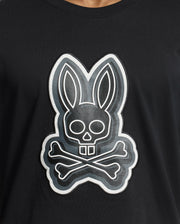 The Psycho Bunny MENS SYDNEY GRAPHIC TEE - B6U508F200 is a black Pima cotton shirt with a bold cartoonish rabbit skull and crossbones graphic in white, creating a striking contrast.