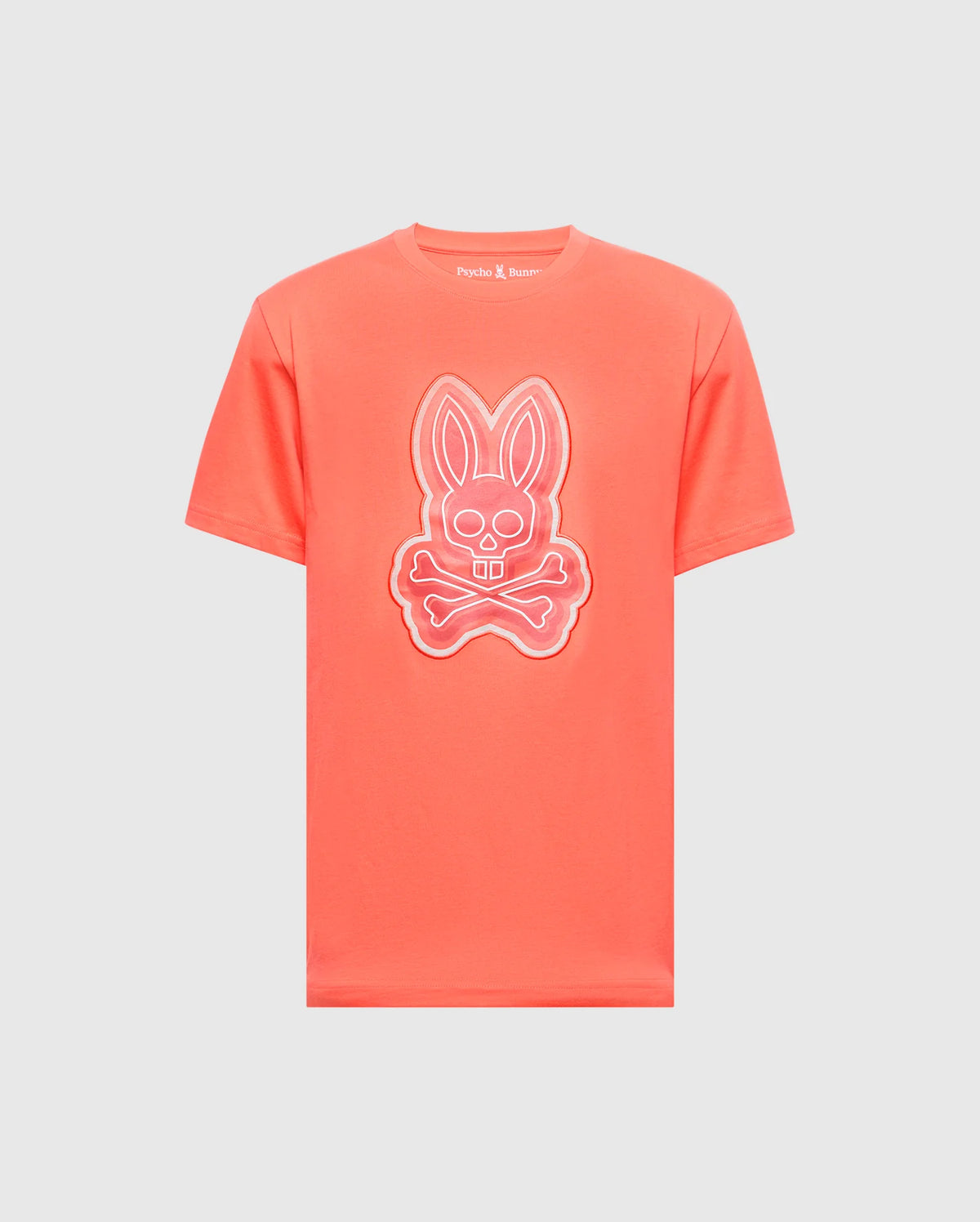 The MENS SYDNEY GRAPHIC TEE - B6U508F200 by Psycho Bunny is a coral-colored, soft Pima cotton T-shirt featuring a glow-in-the-dark bunny with crossed bones graphic on the front.