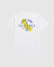 Introducing the Psycho Bunny MENS CALIFORNIA TEE - B6U552W1PC, crafted from breathable Pima cotton jersey in white. This tee showcases a graphic on the back that includes a yellow map outline of California, with "Psycho Bunny California Republic 1850" text. A bunny logo is positioned above the word "California," and a red star appears next to "Republic.
