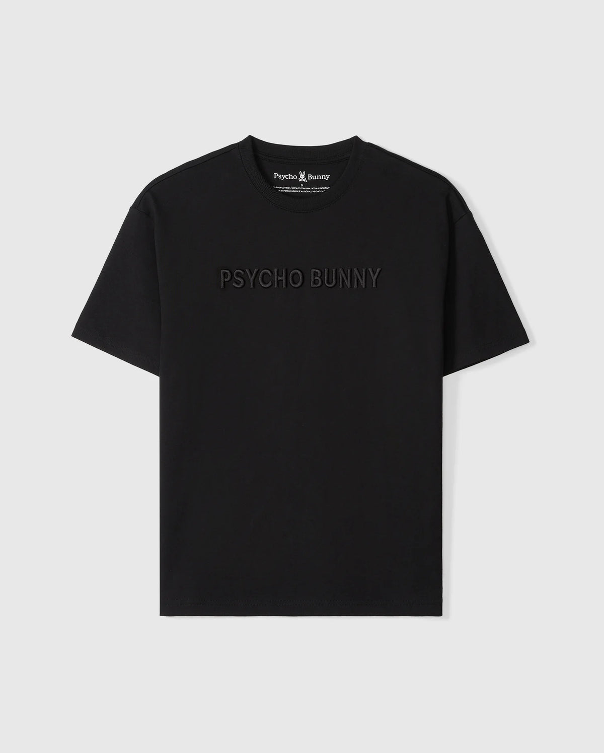 A Psycho Bunny MENS WINDCREST HEAVY WEIGHT TEE - B6U593C200 with the words "psycho bunny" embroidered in subtle raised text across the chest. The image shows the shirt on a plain, light background.