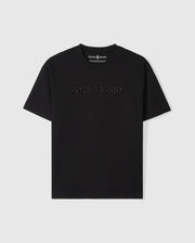 A Psycho Bunny MENS WINDCREST HEAVY WEIGHT TEE - B6U593C200 with the words "psycho bunny" embroidered in subtle raised text across the chest. The image shows the shirt on a plain, light background.