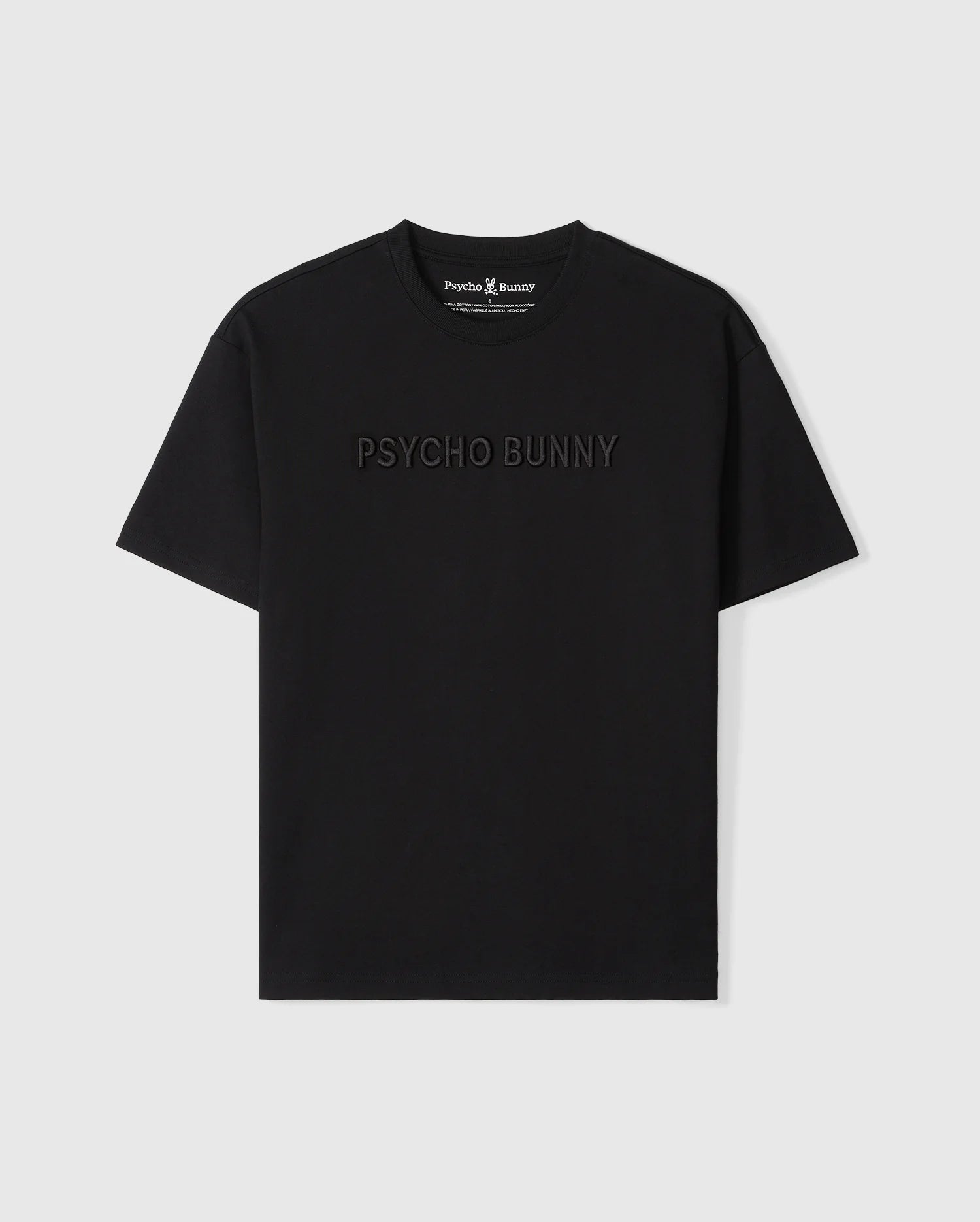 A Psycho Bunny MENS WINDCREST HEAVY WEIGHT TEE - B6U593C200 with the words "psycho bunny" embroidered in subtle raised text across the chest. The image shows the shirt on a plain, light background.