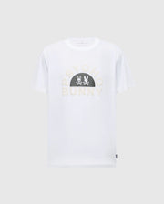 The Men's Goldie Graphic Tee, B6U606F200 by Psycho Bunny, is a white Pima cotton short-sleeve shirt featuring "Psycho Bunny" on the front and a black semicircle with two white bunny silhouettes facing each other, combining style and comfort.