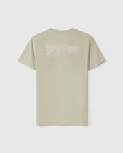 The MENS PEARLAND BACK GRAPHIC TEE - B6U632C200 from Psycho Bunny is a light beige short-sleeve t-shirt displayed on a white background. Crafted from soft Pima cotton, it features the text "Psycho Bunny" in a cursive, white embroidered font on the upper back. This classic crew neck tee offers both style and comfort.