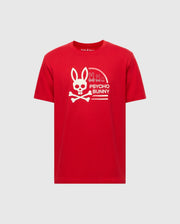 The MENS POLSON GRAPHIC TEE (B6U709E200) by Psycho Bunny is a red T-shirt made from 100% Pima Cotton, featuring a white bunny with crossbones design, the "Psycho Bunny" text, and smaller bunny graphics above the logo.