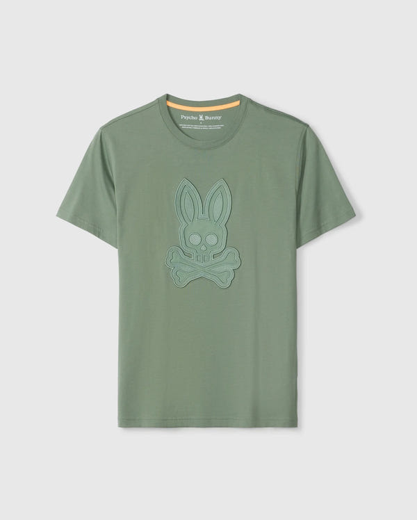 The Psycho Bunny MENS MALTON GRAPHIC TEE - B6U795D200 is a green short-sleeve shirt made from luxurious Pima cotton, featuring a blue embossed design of a bunny skull and crossbones on the front. This Peruvian-crafted tee boasts a round neckline with a yellow inner neck lining.