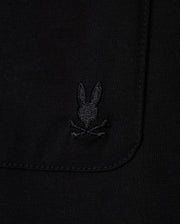 Close-up of the MENS CAMPO POCKET TEE by Psycho Bunny, a black pocket tee made from premium pima cotton, showcasing a subtle embroidered logo with a stylized rabbit's head above crossed bones.