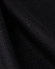 Close-up view of the Psycho Bunny MENS CAMPO POCKET TEE - B6U801D200, crafted from smooth black Pima cotton fabric, showcasing its texture and soft folds. The material appears slightly shiny, with gentle shadows accentuating the drape, reminiscent of a perfectly crafted tee.