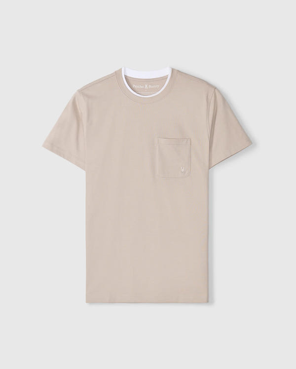 The Psycho Bunny MENS CAMPO POCKET TEE - B6U801D200 is a beige pima cotton shirt with a white crew neck and an embroidered logo on its left-side pocket, set against a light gray background.