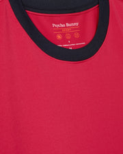 The Psycho Bunny Men's Edmonds Sport Tee (B6U857D200) features a red design with a black collar, crafted from quick-drying antimicrobial fabric. The brand name and care instructions are printed inside near the neckline.