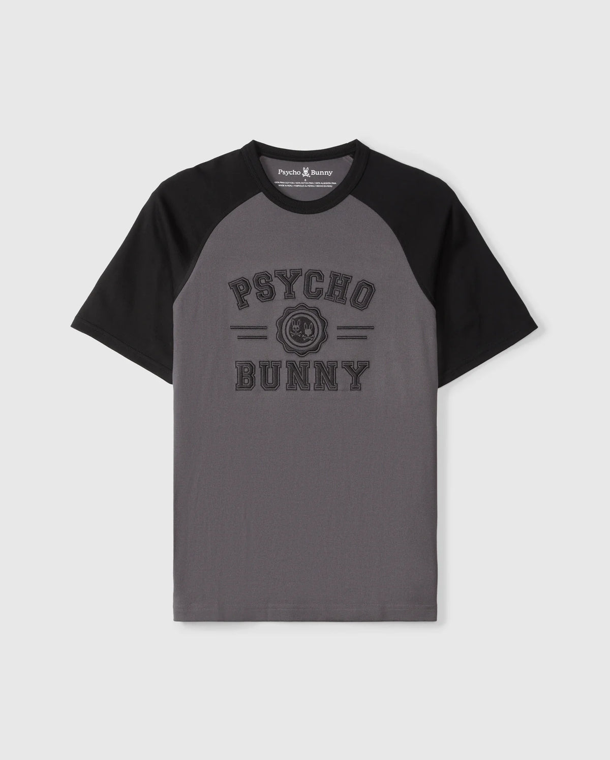 The Psycho Bunny MENS LONDON RAGLAN GRAPHIC TEE - B6U896D200 features gray and black short sleeves, "Psycho Bunny" text on the front with a small bunny logo in between. Made of premium Pima cotton, it combines comfort and style perfectly.