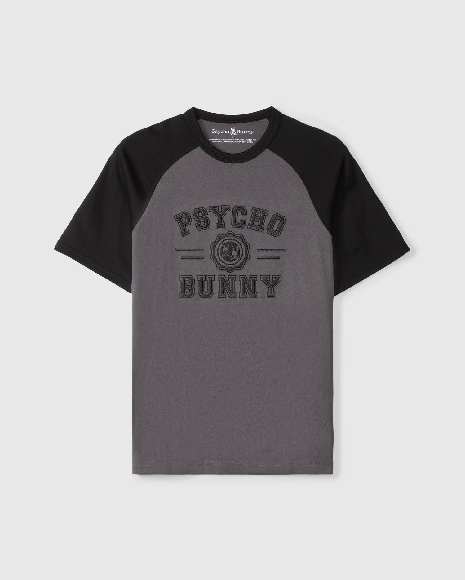 The Psycho Bunny MENS LONDON RAGLAN GRAPHIC TEE - B6U896D200 features gray and black short sleeves, "Psycho Bunny" text on the front with a small bunny logo in between. Made of premium Pima cotton, it combines comfort and style perfectly.