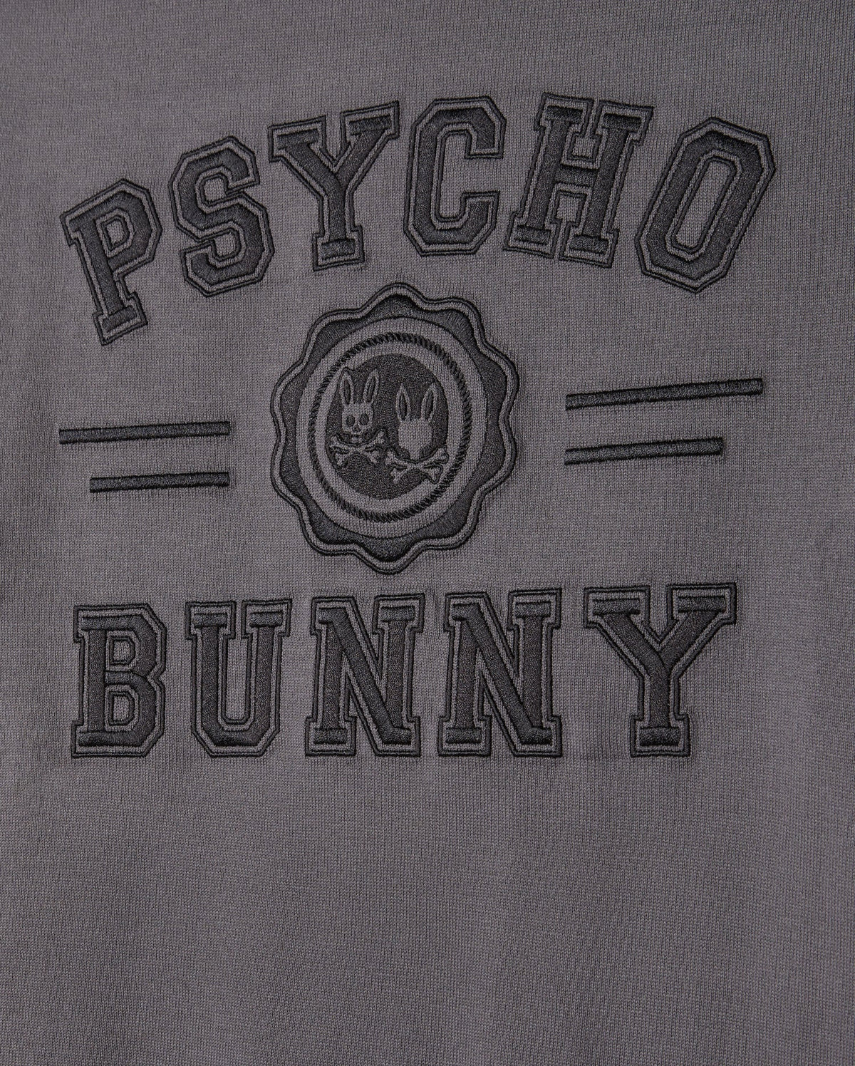 The MENS LONDON RAGLAN GRAPHIC TEE by Psycho Bunny features uppercase "PSYCHO BUNNY" embroidery on gray Pima cotton. A round emblem of two mischievous bunnies takes center stage, framed by subtle horizontal stripes for a unique style.