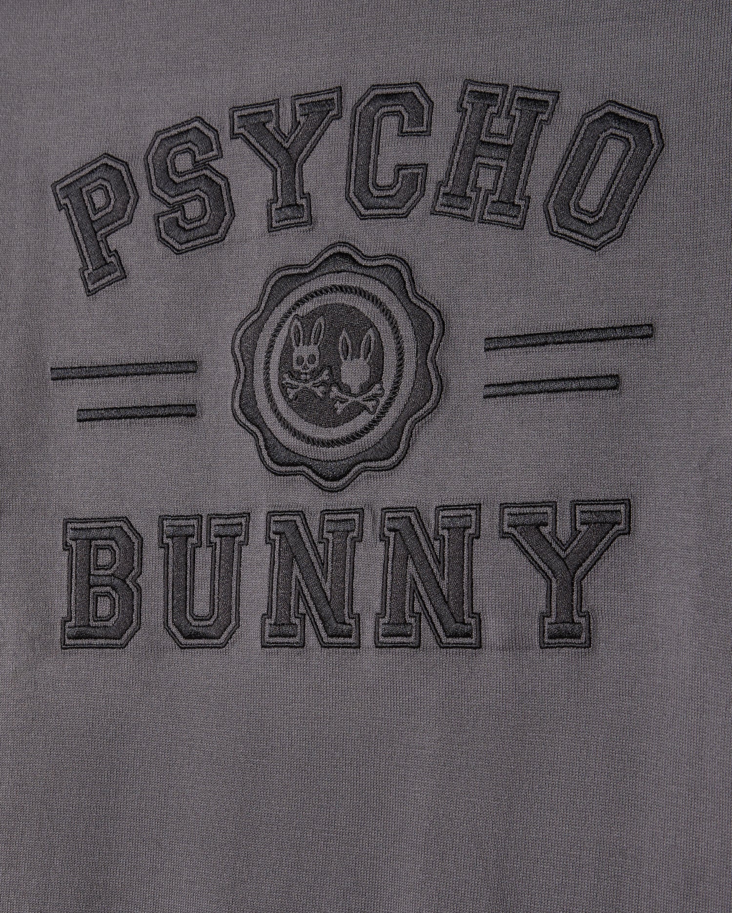 The MENS LONDON RAGLAN GRAPHIC TEE by Psycho Bunny features uppercase "PSYCHO BUNNY" embroidery on gray Pima cotton. A round emblem of two mischievous bunnies takes center stage, framed by subtle horizontal stripes for a unique style.