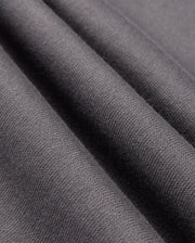 Close-up of the smooth, dark gray fabric from the Psycho Bunny MENS LONDON RAGLAN GRAPHIC TEE, B6U896D200, showcases a visible weave texture with soft folds reminiscent of a heavyweight jersey tee, adding depth and elegance.
